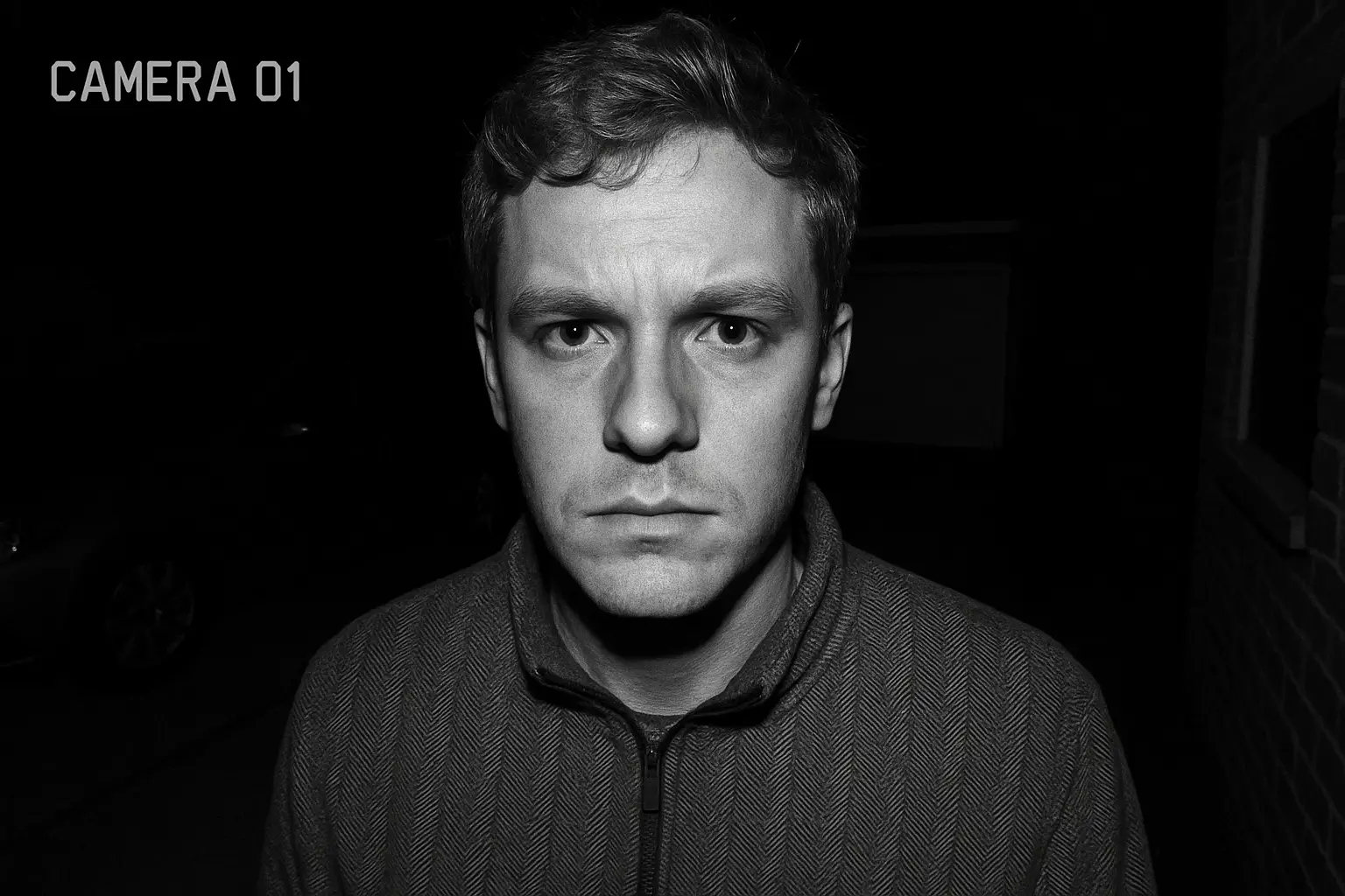 A very clear black and white image from a security camera showing details on a person's face at night